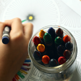 Criança a pintar com lápis de cera